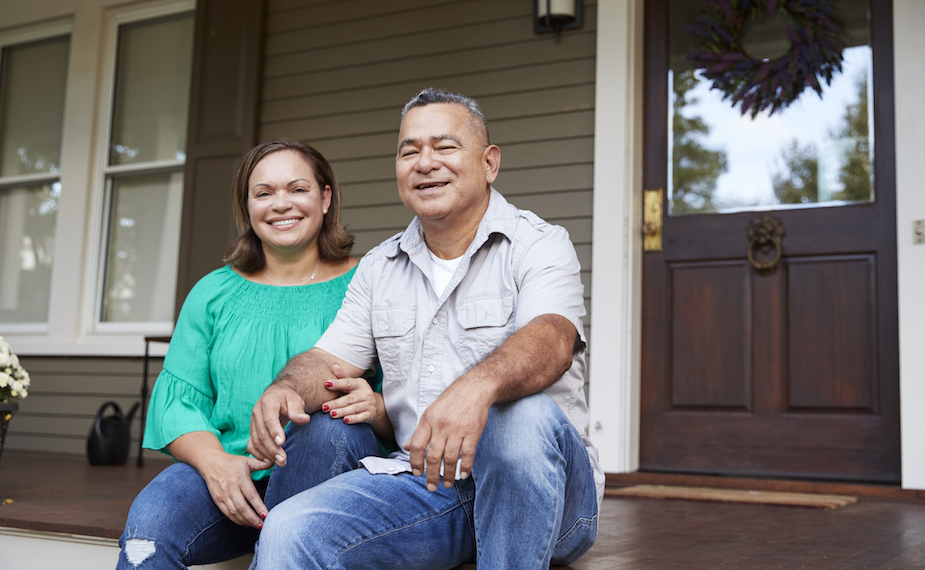 Couple sitting on front porch of house