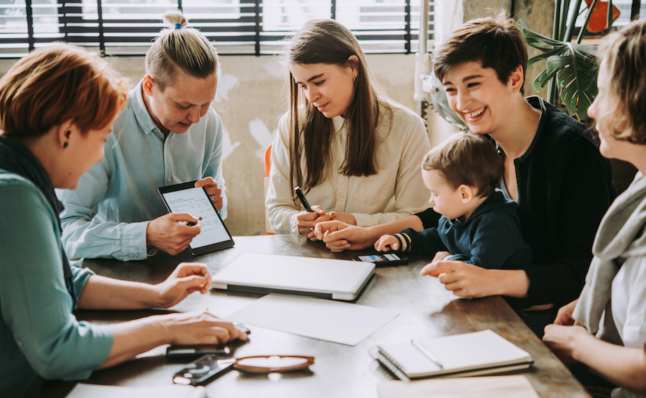 Group of people sit and talk around a table